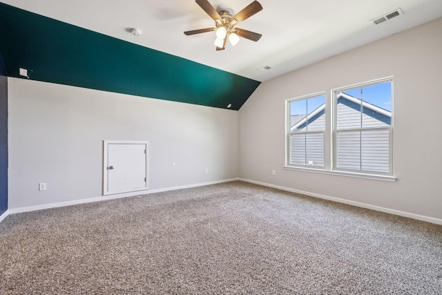 interior space featuring ceiling fan, visible vents, vaulted ceiling, baseboards, and carpet flooring
