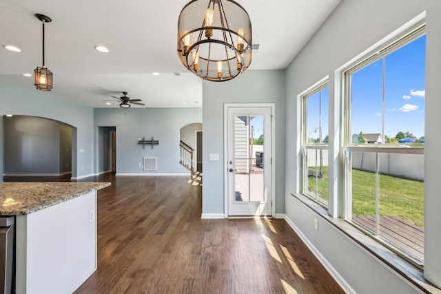 entryway with baseboards, dark wood-style floors, recessed lighting, arched walkways, and ceiling fan with notable chandelier