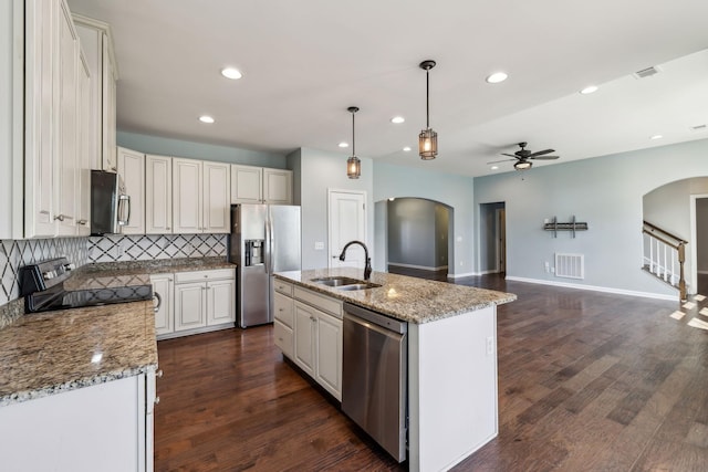 kitchen featuring arched walkways, a ceiling fan, a sink, and stainless steel appliances