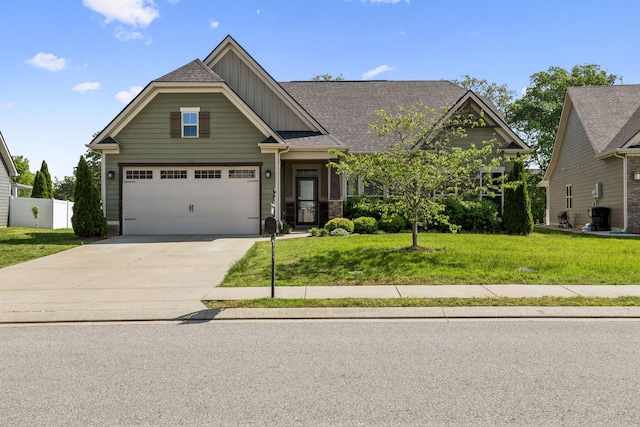 craftsman-style home featuring fence, a garage, board and batten siding, a front yard, and driveway