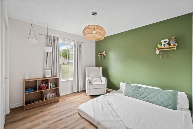 bedroom featuring baseboards and wood finished floors