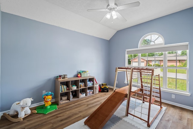 game room with baseboards, lofted ceiling, wood finished floors, and a healthy amount of sunlight