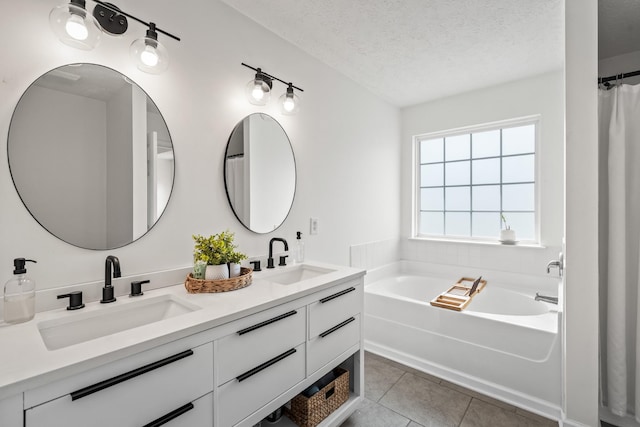 full bathroom featuring tile patterned flooring, a sink, a textured ceiling, and a garden tub