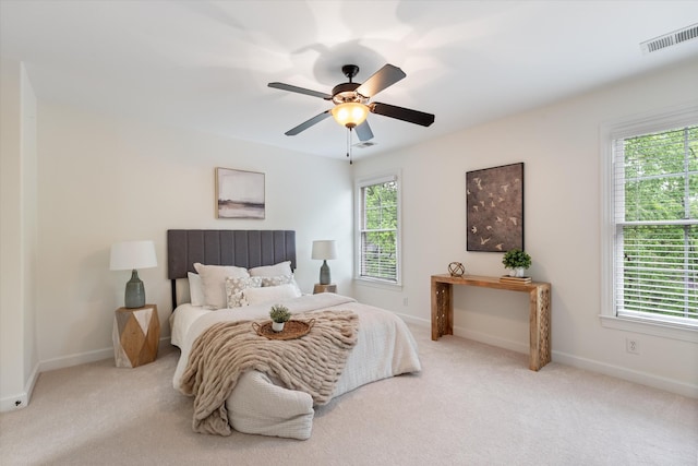 carpeted bedroom with baseboards, multiple windows, and visible vents