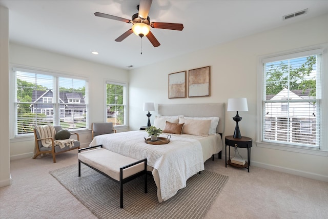 bedroom featuring baseboards, multiple windows, light carpet, and visible vents