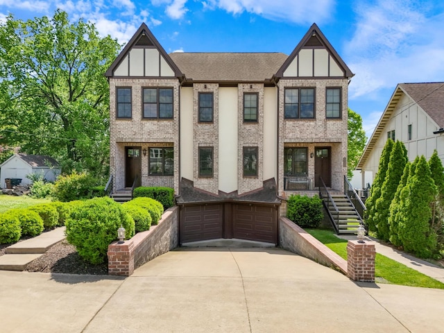 view of front of home with an attached garage, concrete driveway, and a porch