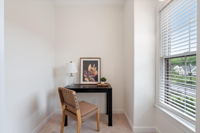 home office featuring baseboards, a healthy amount of sunlight, and light carpet