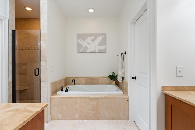 bathroom with a stall shower, recessed lighting, a garden tub, and vanity