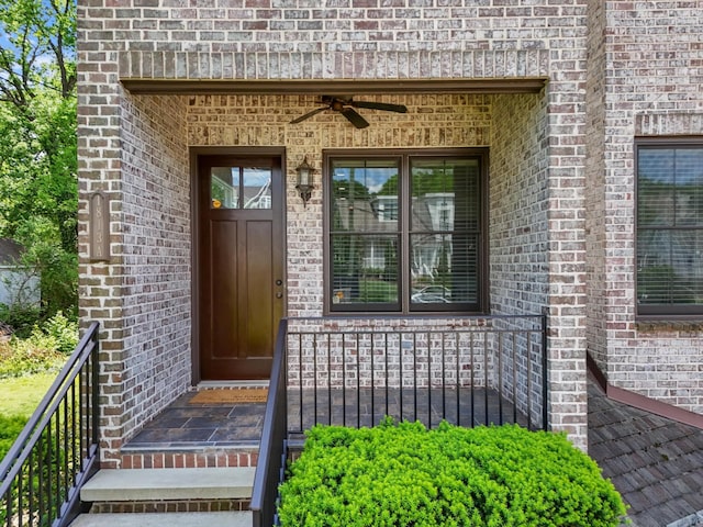 entrance to property with ceiling fan and brick siding
