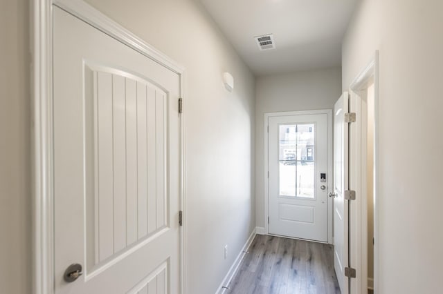 doorway with visible vents, baseboards, and light wood-type flooring