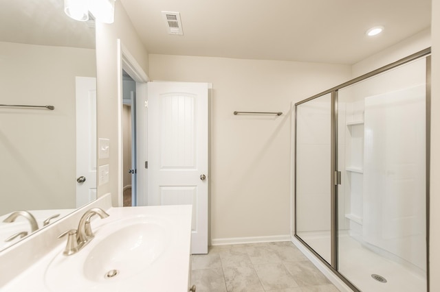 bathroom with vanity, a shower stall, and visible vents