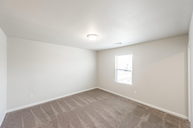 empty room featuring baseboards, carpet flooring, and visible vents