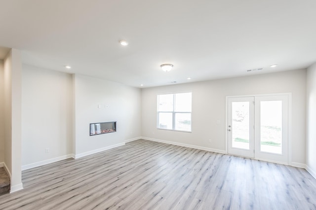 unfurnished living room with recessed lighting, baseboards, light wood-type flooring, and visible vents