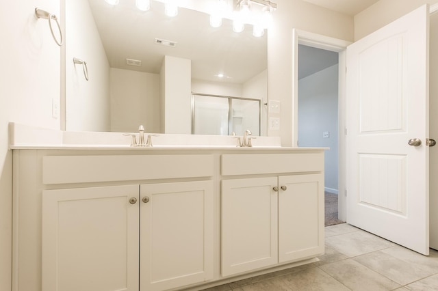 bathroom featuring double vanity, visible vents, a stall shower, a sink, and tile patterned floors