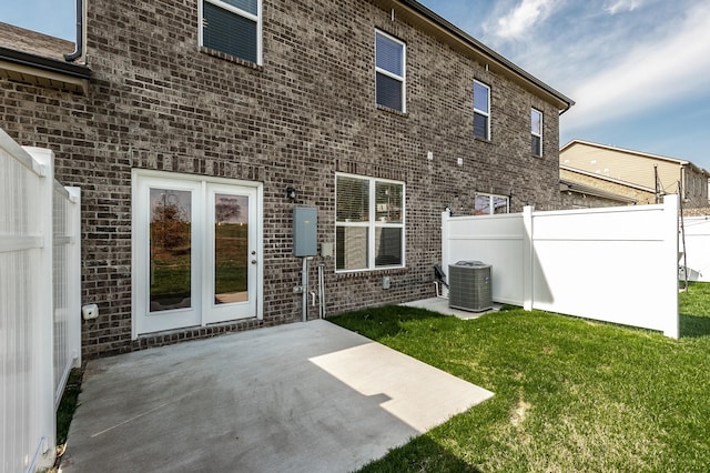 rear view of house with a patio, a lawn, central air condition unit, and fence