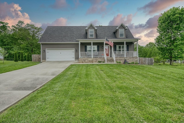 cape cod home featuring an attached garage, a front lawn, covered porch, and concrete driveway