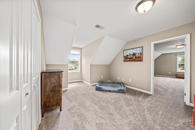 bedroom featuring carpet floors, baseboards, vaulted ceiling, and visible vents