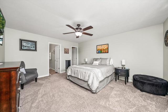 carpeted bedroom with baseboards, ceiling fan, and ensuite bath