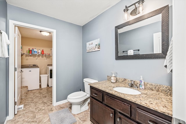 bathroom featuring washer and dryer, toilet, a walk in closet, and vanity