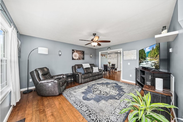 living room with baseboards, a ceiling fan, and wood finished floors