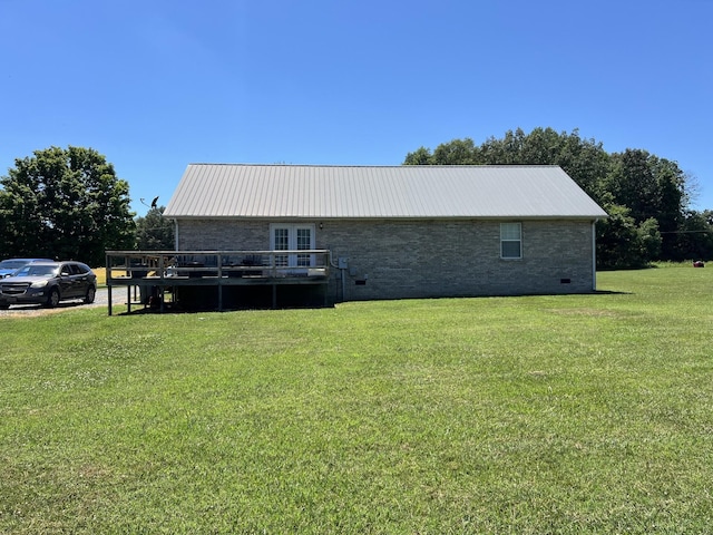 back of house featuring a yard, french doors, a deck, and metal roof