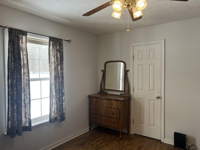 bedroom with baseboards, a textured ceiling, ceiling fan, and wood finished floors