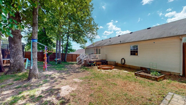 view of yard with a fenced backyard, a wooden deck, and a vegetable garden