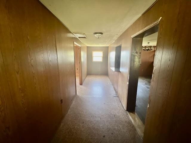 corridor with wood walls and tile patterned floors