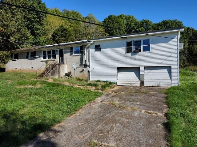 ranch-style home with concrete driveway, a front yard, and a garage