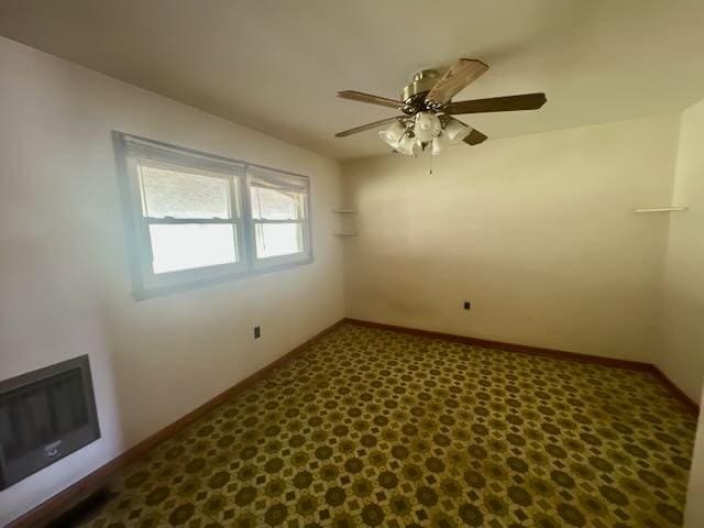 spare room with baseboards and ceiling fan