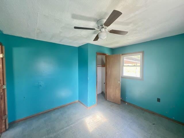 unfurnished bedroom with baseboards, a ceiling fan, a closet, and a textured ceiling