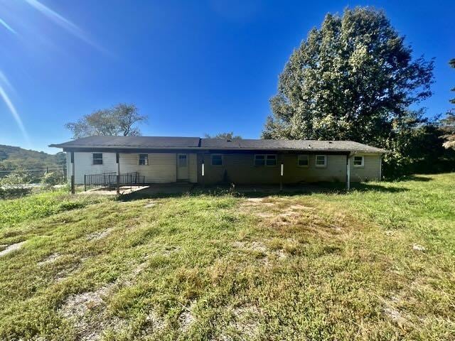 rear view of property with fence and a yard