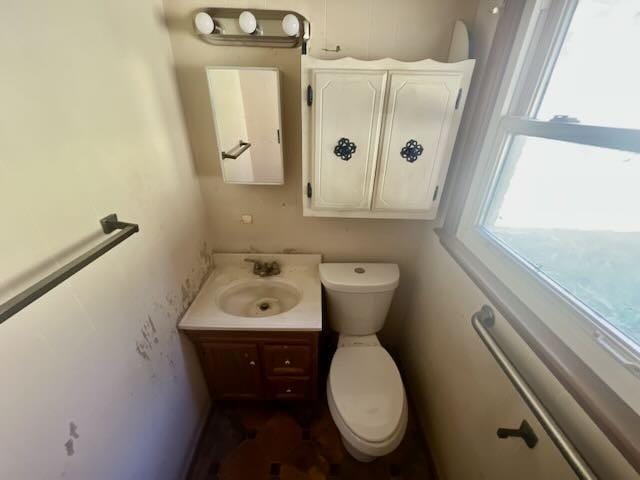 half bath featuring vanity and toilet