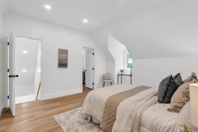 bedroom featuring recessed lighting, baseboards, vaulted ceiling, and light wood finished floors