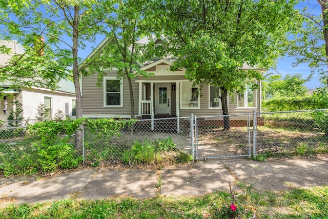 view of front of home with covered porch, a fenced front yard, and a gate