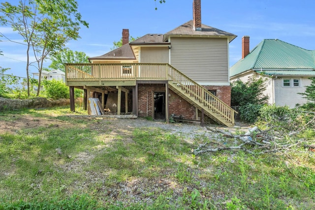 back of house with stairway, brick siding, a wooden deck, and a chimney