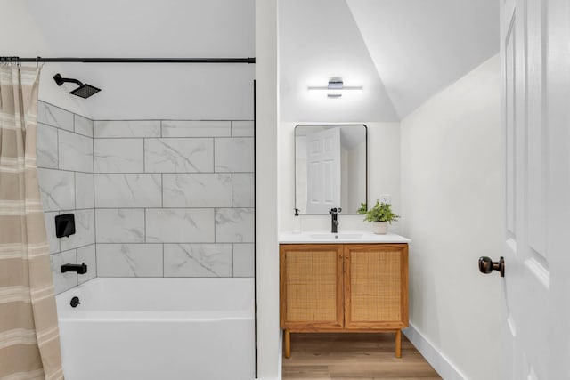 bathroom featuring vanity, wood finished floors, shower / bath combination with curtain, and vaulted ceiling