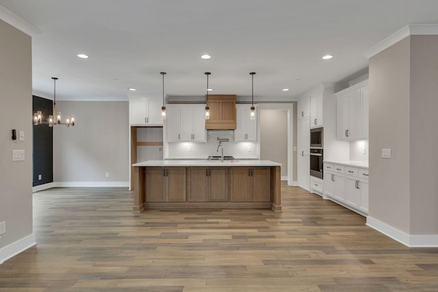 kitchen featuring baseboards, wood finished floors, white cabinets, and tasteful backsplash