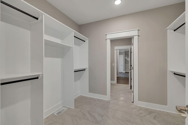 spacious closet featuring visible vents and marble finish floor