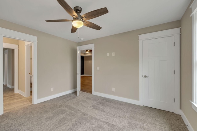 unfurnished bedroom featuring baseboards, a ceiling fan, and light carpet