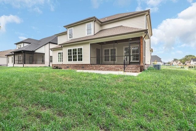 back of property with a ceiling fan, a sunroom, brick siding, central AC, and a yard