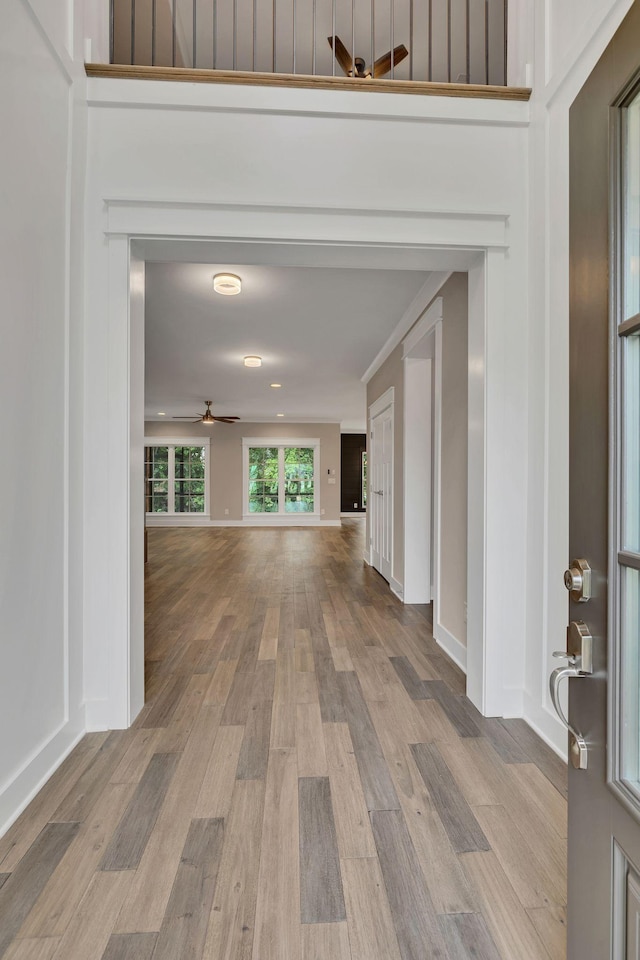 corridor featuring baseboards and wood finished floors