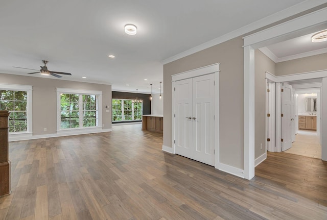 unfurnished living room with a ceiling fan, baseboards, recessed lighting, wood finished floors, and ornamental molding