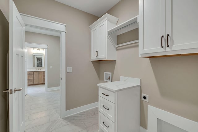 clothes washing area with electric dryer hookup, cabinet space, baseboards, hookup for a washing machine, and marble finish floor