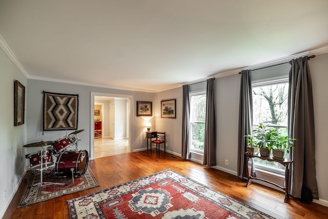 living area with ornamental molding and hardwood / wood-style flooring