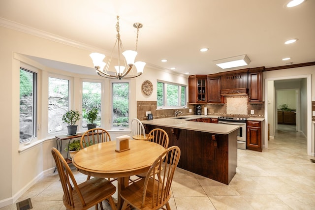 kitchen with a sink, ornamental molding, a peninsula, and electric stove