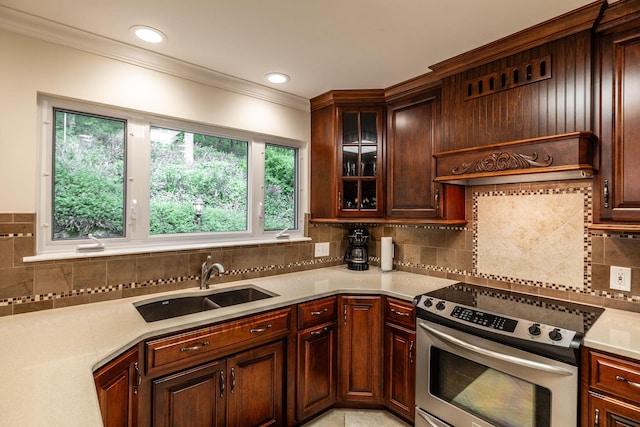 kitchen with crown molding, stainless steel electric range oven, tasteful backsplash, a sink, and light countertops