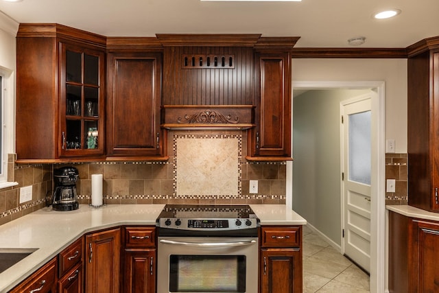 kitchen featuring electric stove, backsplash, light tile patterned flooring, and light countertops
