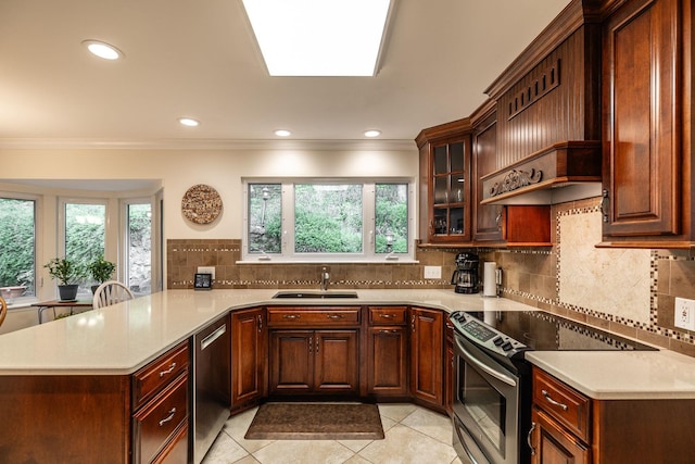 kitchen with ornamental molding, a peninsula, light countertops, a sink, and stainless steel appliances