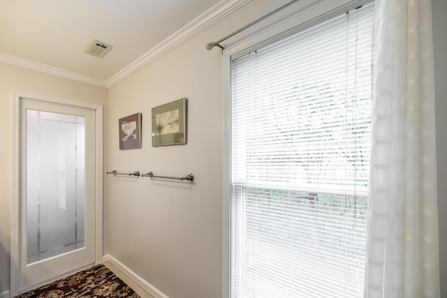 doorway to outside featuring baseboards, ornamental molding, and visible vents